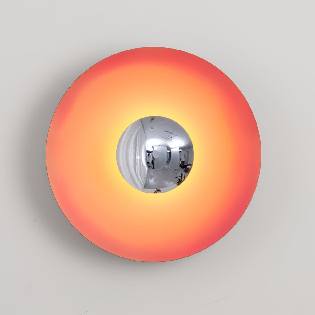 The chrome centre of this coral-orange Clérachic wall light reflects a soft highlight, shown on grey.