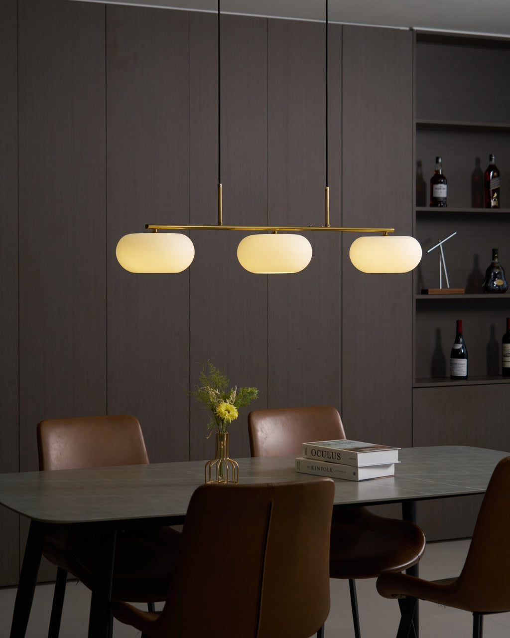 Detail of linear pendant bar holding white glass globes
