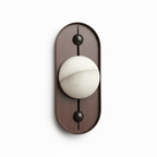 Front view of the oval walnut Koyan wall light unlit, black ball fittings above and below the globe.