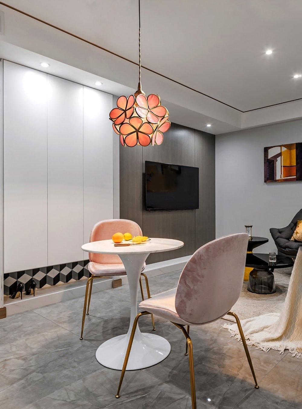 White glass petal pendant light glowing over a counter