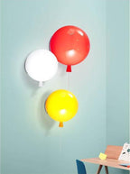 Balloon wall sconce with pull cord glowing in a nursery