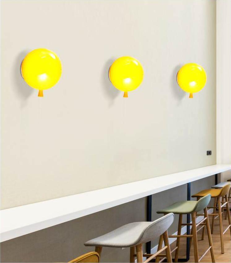 Colourful balloon wall sconce glowing against a wall