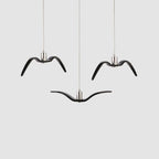 Three black bird-shaped pendants from this Clérachic fixture hang together against a plain light-grey backdrop.