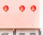 Balloon-shaped wall light lit warmly in an interior