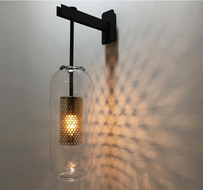 Wall lamp with glass shade mounted near a window frame