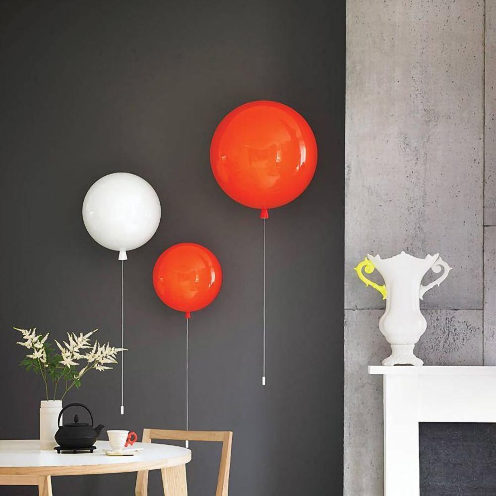 Balloon wall light glowing warm above a bedside table
