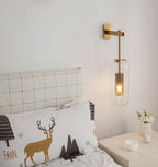 Copper-finish glass wall lamp lighting a cozy interior corner