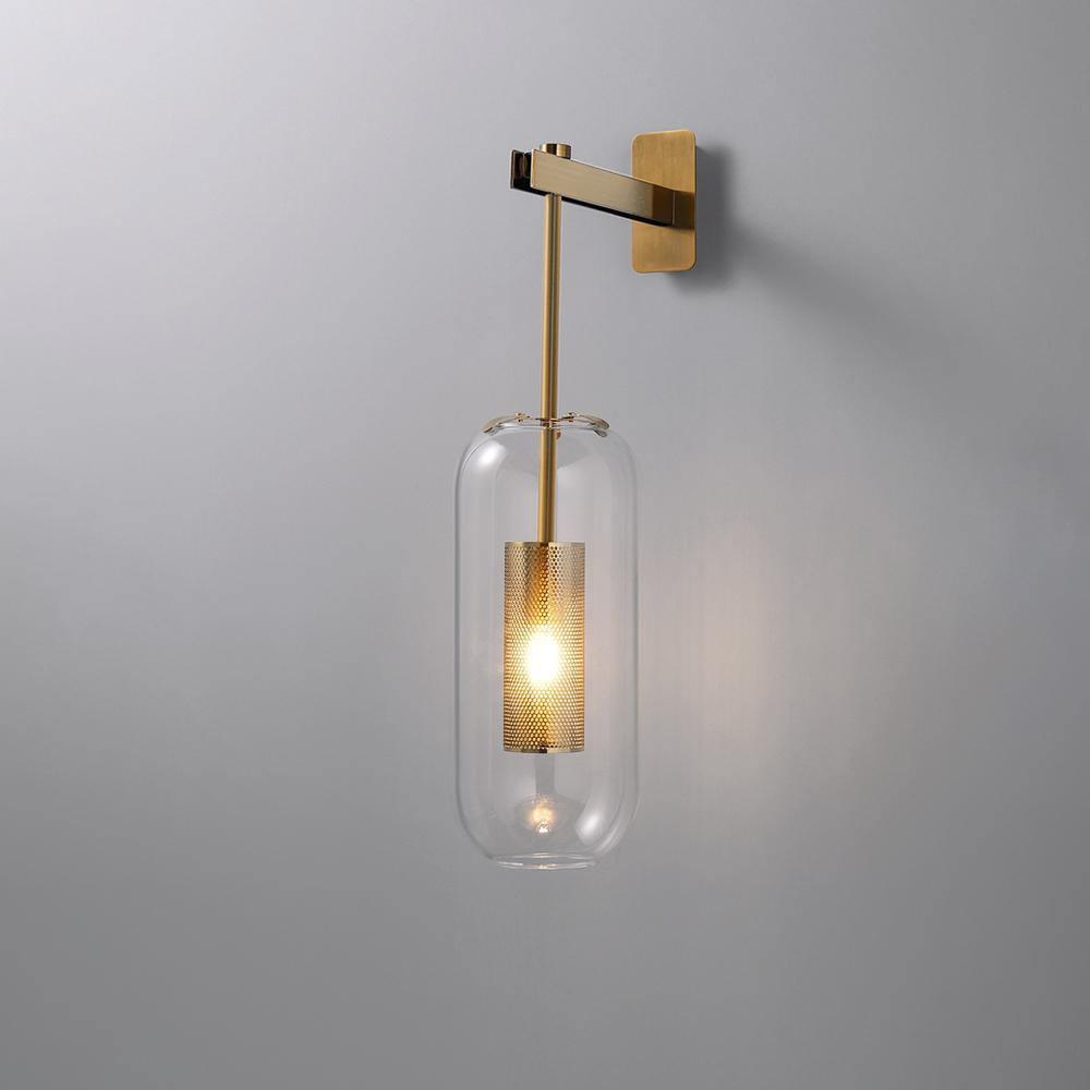 Wall lamp with glass shade glowing softly above a console table