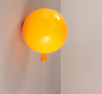 Sculptural balloon wall sconce lit softly in a bedroom