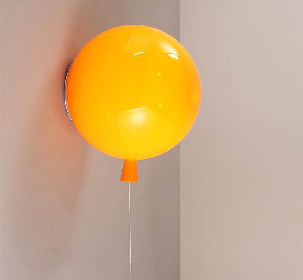 Sculptural balloon wall sconce lit softly in a bedroom