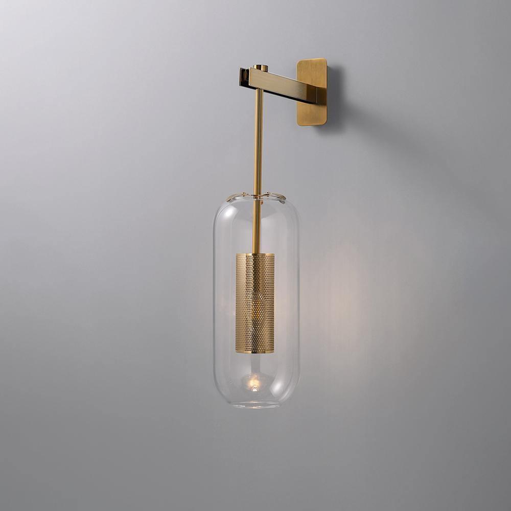Glass wall lamp with slim arm casting warm light on a wall