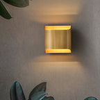 Solid brass wall sconce photographed against a dark backdrop