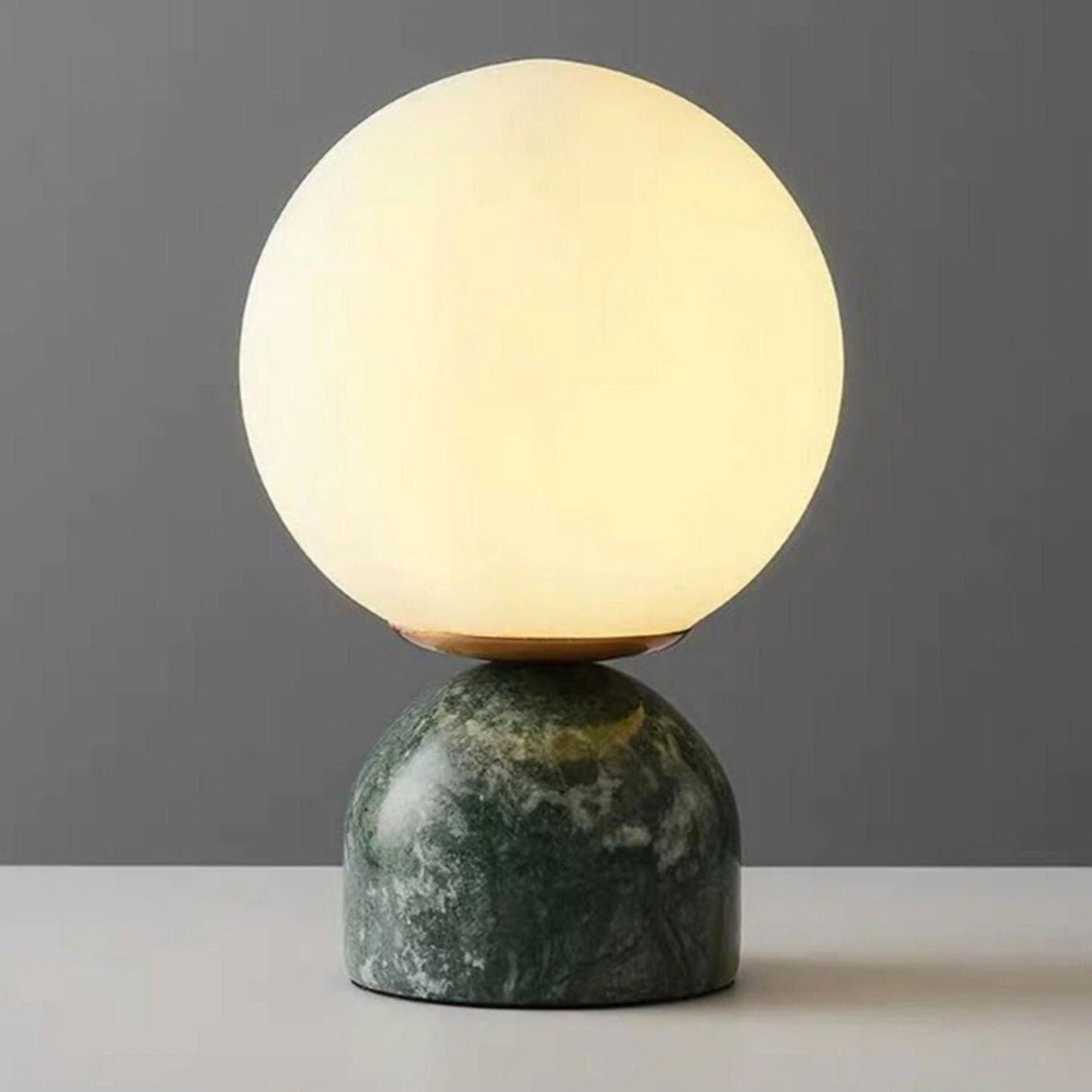 Sylas lamp with white glass orb on a black marble base