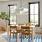 Elysia pendant light glowing warmly over a seating area