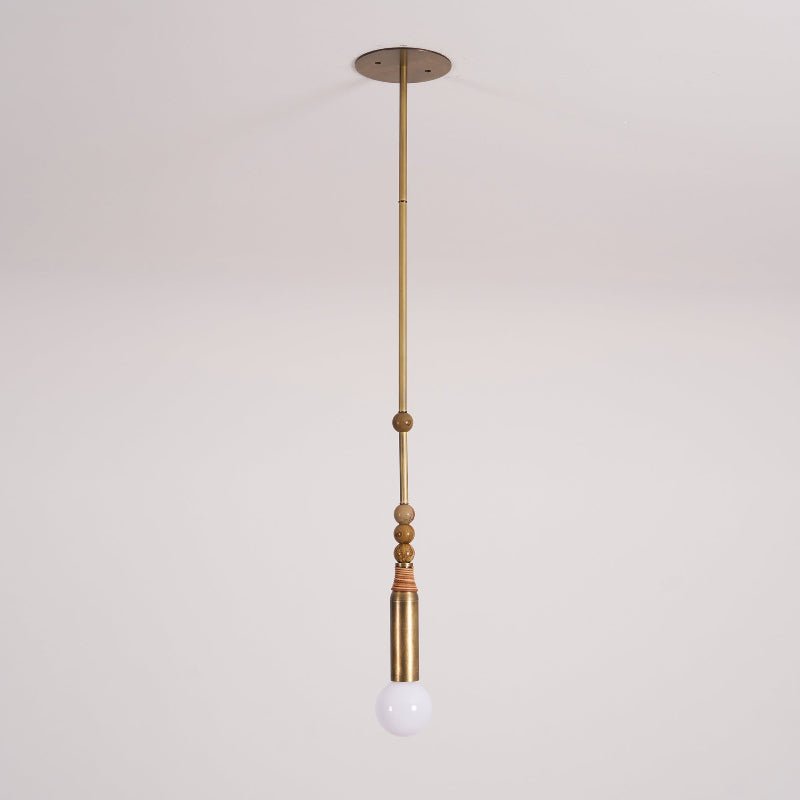 The Clérachic pendant light pictured alone on a light backdrop, showing its slim brass rod and glowing bulb.