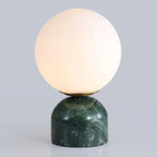 Marble base table lamp lit with a warm glow on a side table