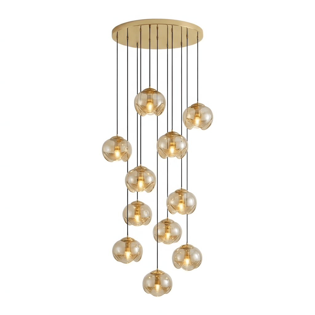 A large tiered cluster of amber glass shades cascades from a gold ceiling plate, this Clérachic fixture shown densely packed on white.
