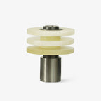 Tiered alabaster table lamp unlit on a plain white background, three stacked stone discs on a gunmetal base
