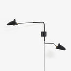 Wall sconce arm and shade detail against a pale interior wall