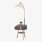 Clérachic pleated-shade arc floor lamp with its round charcoal side table, drawer closed, shown alone on a plain backdrop.