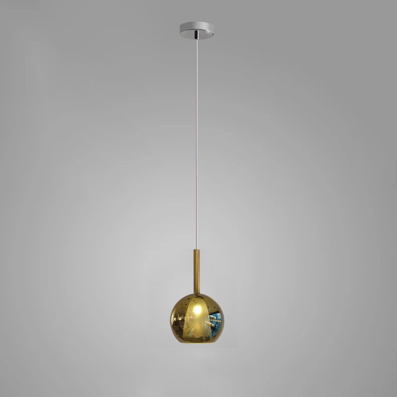 Glass globe pendant light shown lit in a reading corner