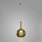 Glass globe pendant light glowing softly above an island