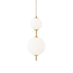 Vertical globe pendant light glowing above a dining table