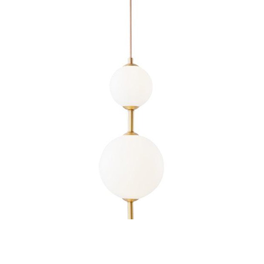 Vertical globe pendant light glowing above a dining table