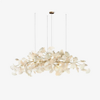 Horizontal leaf chandelier glowing over a dining setting