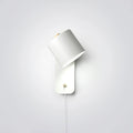 Cylinder wall lamp with rotatable shade mounted on a bedroom wall