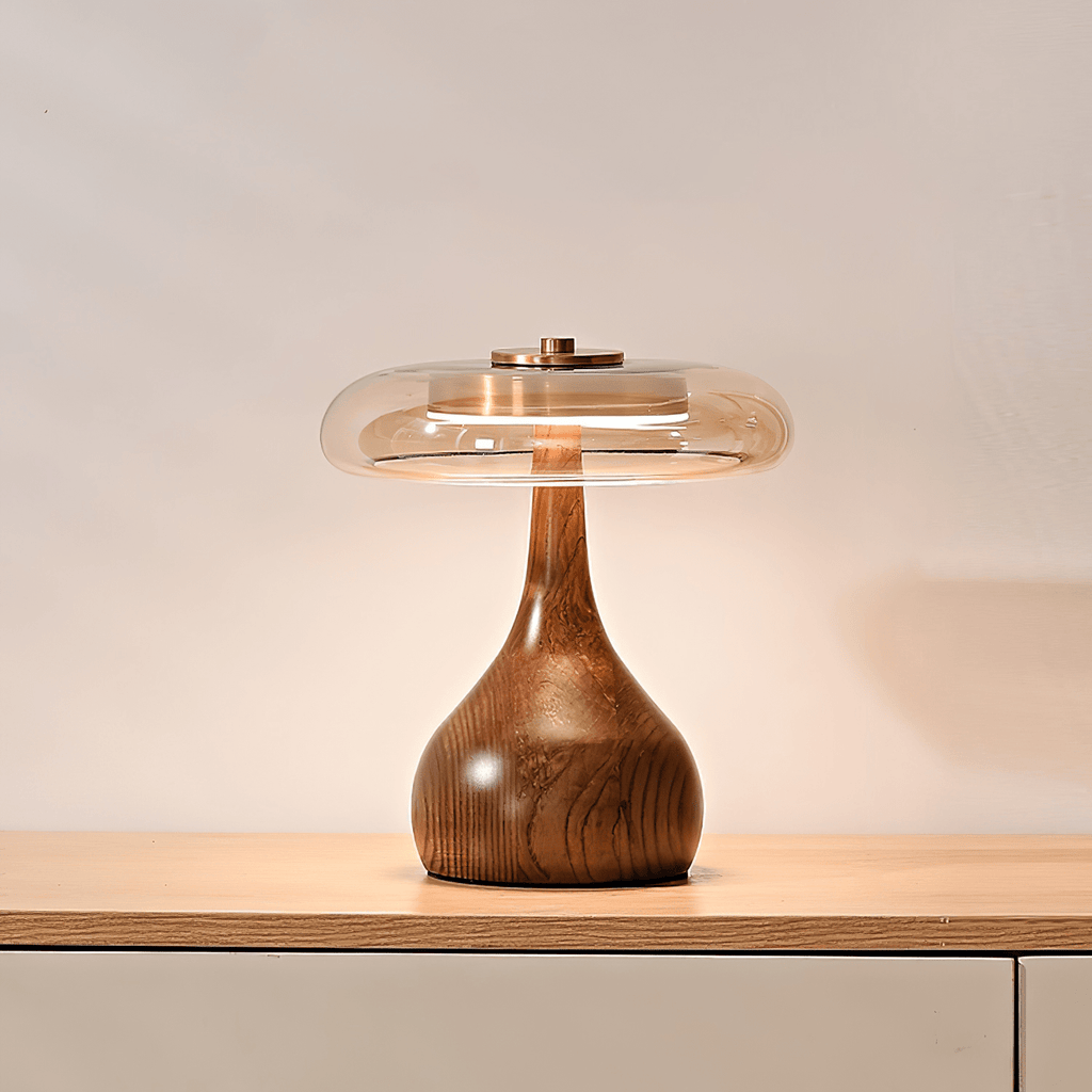 Table lamp with walnut wood base and amber glass shade glowing