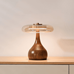 Table lamp with walnut wood base and amber glass shade glowing