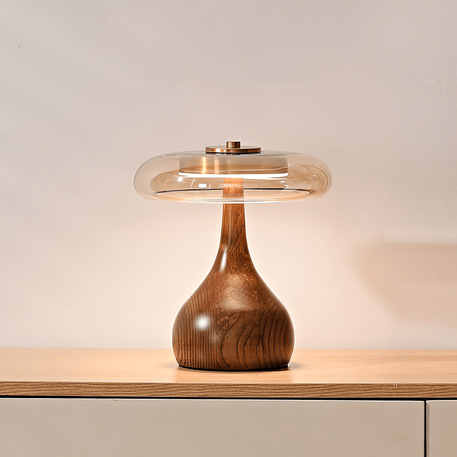 Table lamp with walnut wood base and amber glass shade glowing