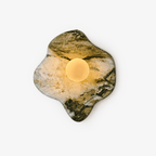 Lit warm against a white studio backdrop, this Clérachic stone wall light shows its irregular green-and-white marble outline.