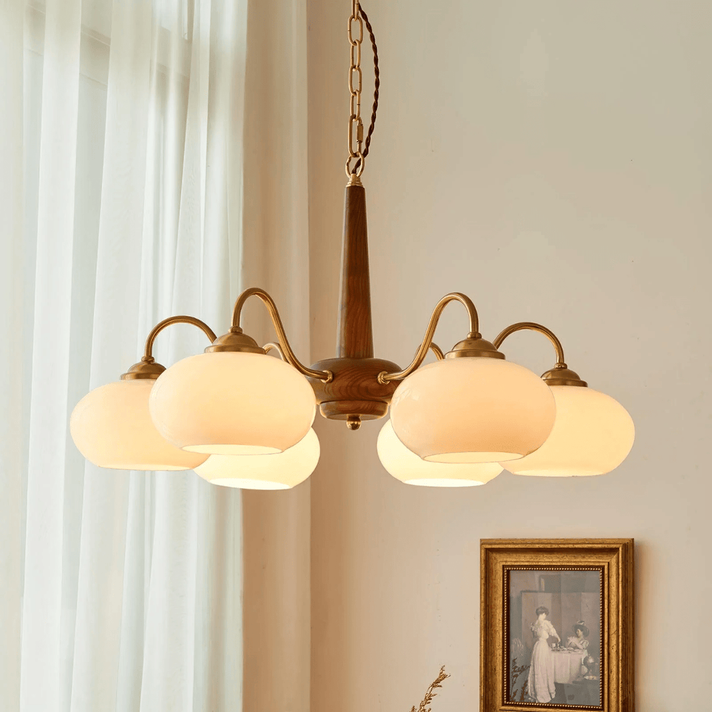 Sheer curtains and a small sepia-toned print hang beside this Clérachic chandelier's six cream shades.