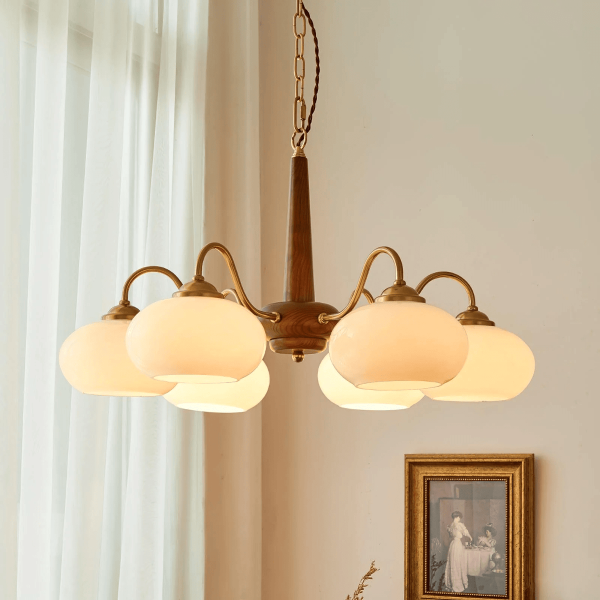 Sheer curtains and a small sepia-toned print hang beside this Clérachic chandelier's six cream shades.