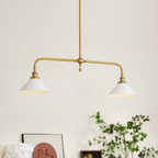 Against a plain cream wall, this Clérachic pendant hangs lit warm beside a leaning framed print and potted greenery.