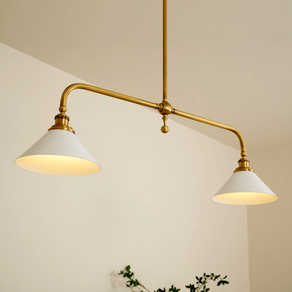 A closer angle on this Clérachic pendant shows both white conical shades glowing warm against a plain cream wall.