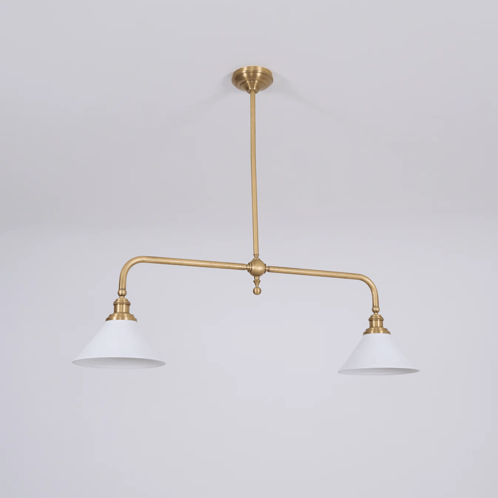 On a plain grey background, this Clérachic pendant stands unlit, its brass frame fully visible.