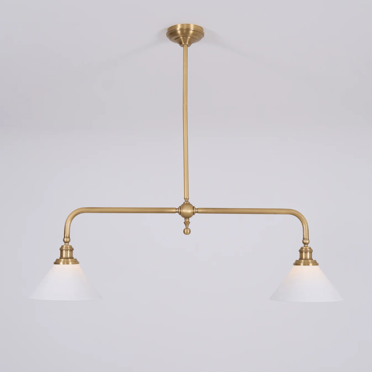 This Clérachic pendant sits unlit on a plain grey background, its brass stem centred above two matching shades.