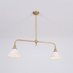 Warm light glows from both shades of this Clérachic pendant, shown on a plain grey background.