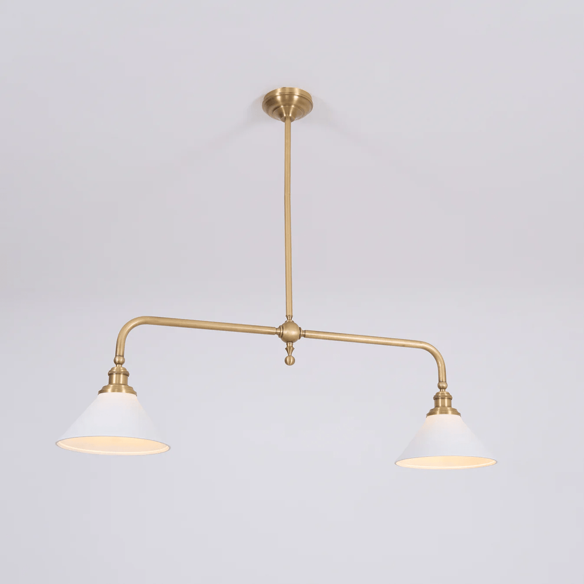 Warm light glows from both shades of this Clérachic pendant, shown on a plain grey background.