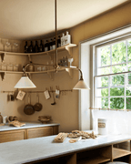 Two white conical shades on this Clérachic pendant glow warm above an open-shelf kitchen counter with wine glasses and hanging pans.