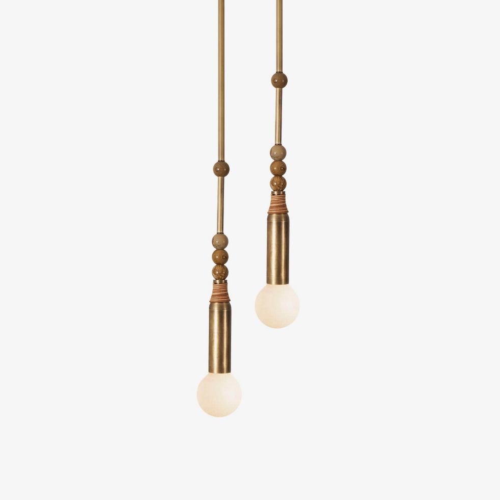 Two Clérachic pendant lights at different drop lengths, each with a marble bead stem and a lit glass bulb.