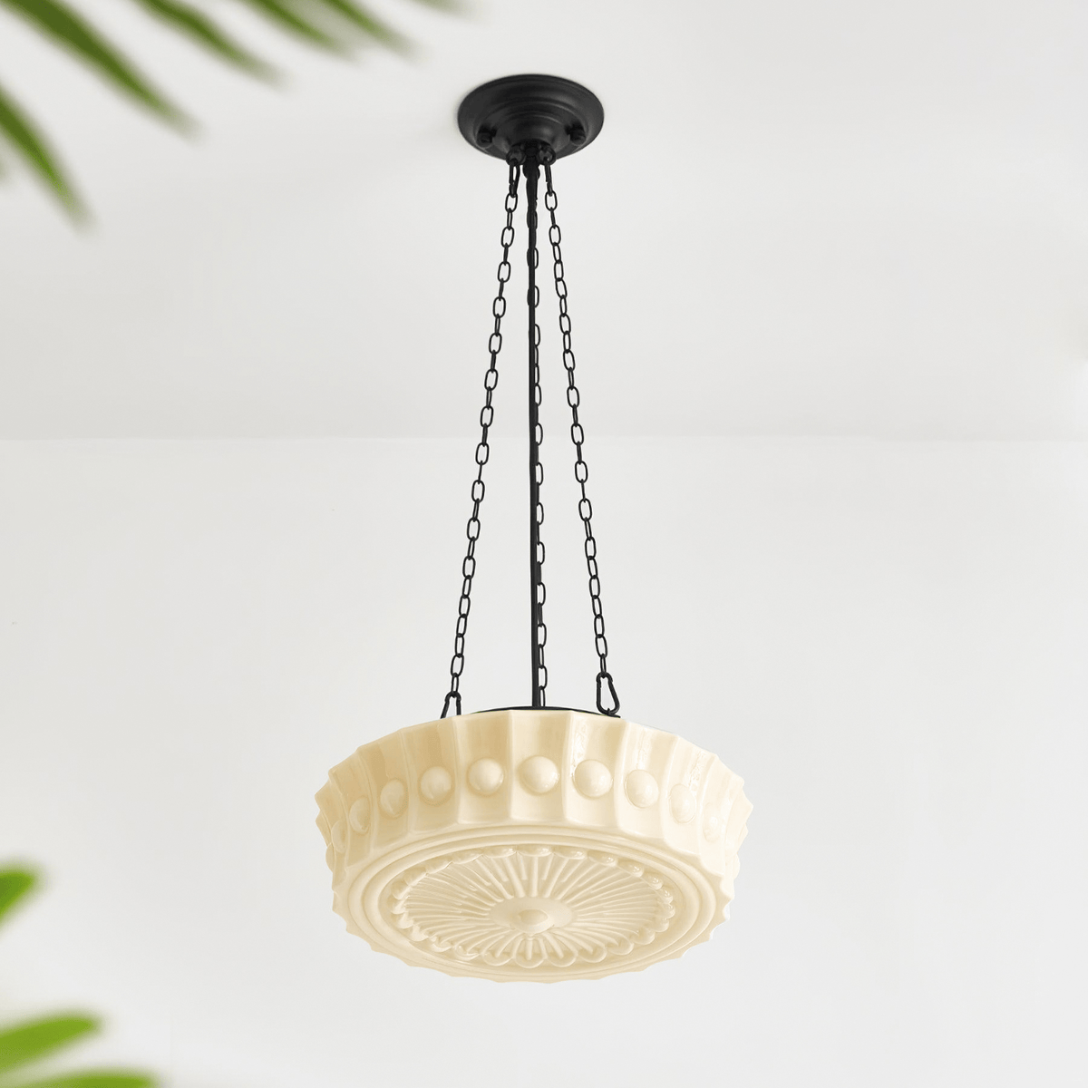 A close angled view of this beige fluted-glass Clérachic pendant, unlit, its fluted ribs and sunburst diffuser visible from below.