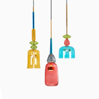 An amber bell shade and a teal bell shade flank a closer coral bottle shade on this Clérachic pendant, on white.