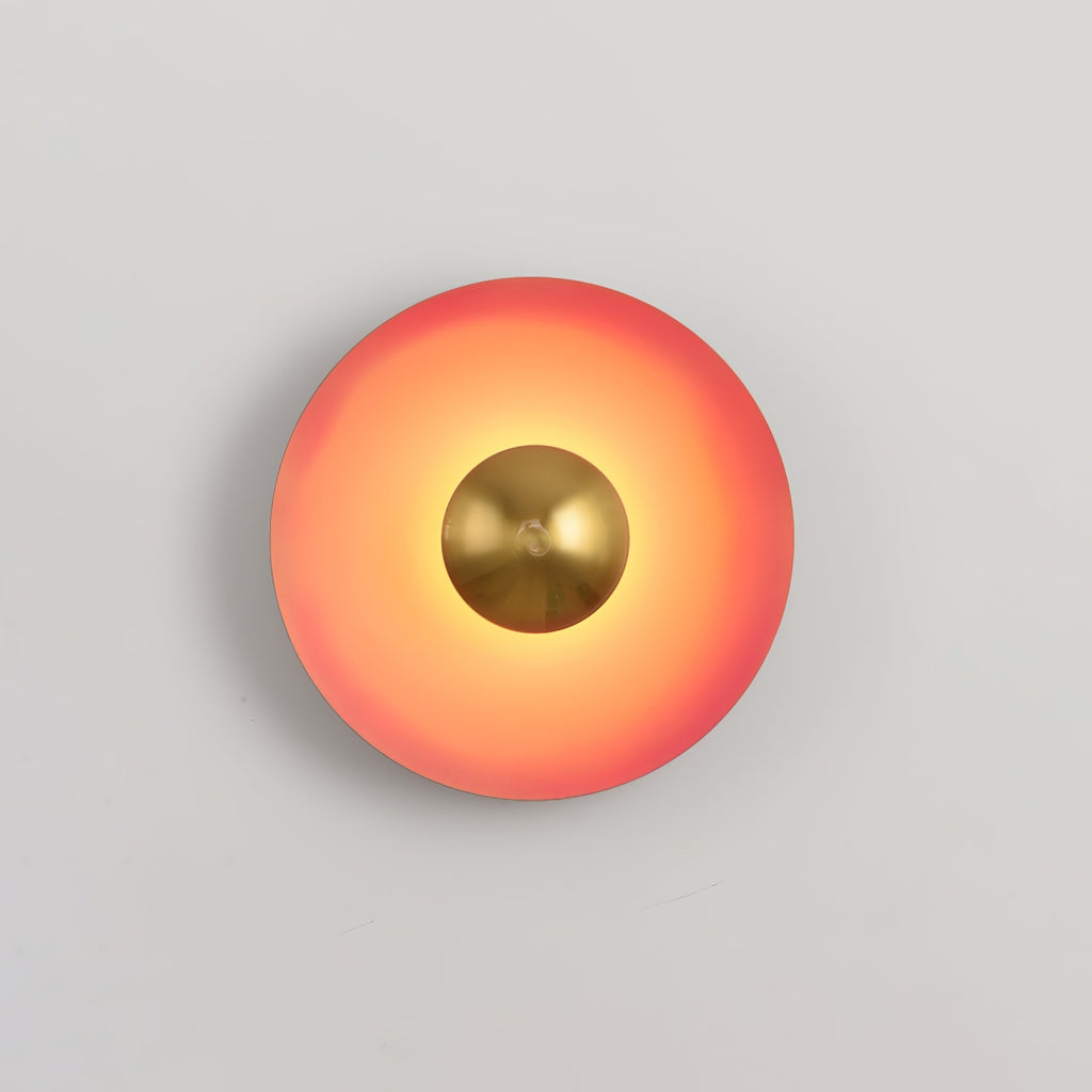This coral-orange Clérachic wall light's antique copper centre sits small and bright against the warm shade.