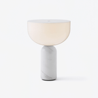Clérachic hallway table lamp with a frosted white glass dome lit warm above a veined white marble cylinder base, shown on a plain light backdrop.