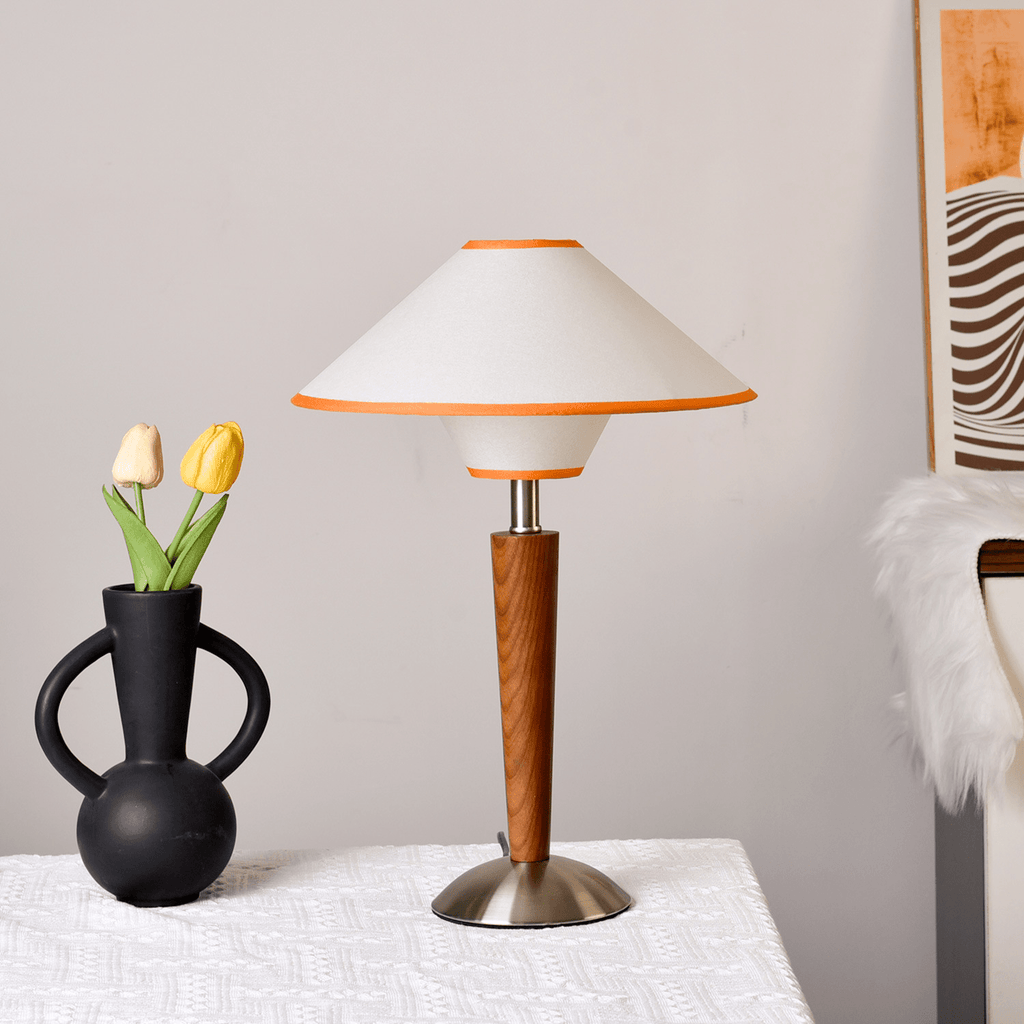 Walnut base lamp with soft fabric shade casting warm light