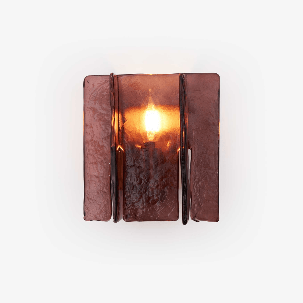 Gold brass wall sconce casting geometric light patterns across a wall